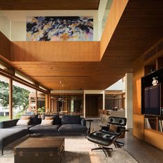 a living room filled with furniture and a flat screen tv mounted to the wall above it