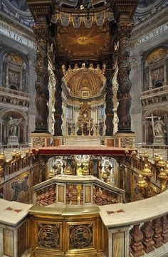 an ornately decorated church with gold and white decorations on the alter, looking down at the pews