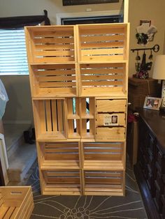 wooden crates stacked on top of each other in front of a dresser with drawers underneath