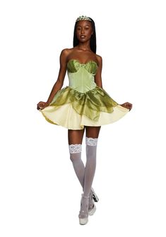 a woman in a green and yellow dress with white stockings on her feet is posing for the camera