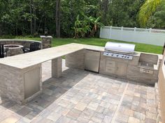 an outdoor kitchen with grill and seating area