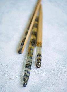 three wooden chopsticks sitting next to each other on a white tablecloth covered surface