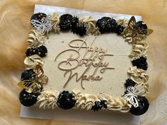 a birthday cake with white frosting and black flowers on it that says happy birthday mike