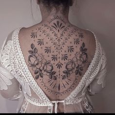 the back of a woman's neck with tattoos on it