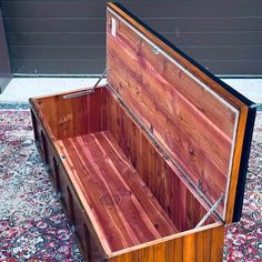 an open wooden box sitting on top of a carpeted floor next to a wall