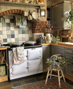 an old fashioned stove in a kitchen with pots and pans hanging on the wall