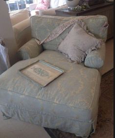 a blue chair with pillows on it in a living room