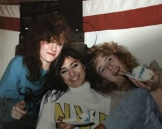 three women are posing for the camera while brushing their teeth