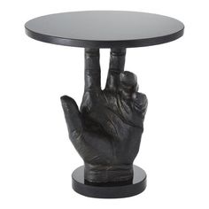 a black table with a hand holding up the middle finger to it's base