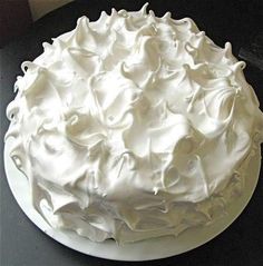 a white frosted cake sitting on top of a table