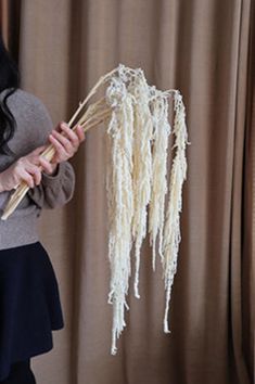 a woman is holding some white flowers in her hands