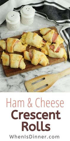 ham and cheese crescent rolls on a wooden cutting board with a black and white towel