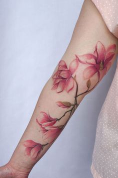 a woman's arm with pink flowers on it