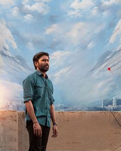 a man standing in front of a painting with clouds above him and a kite flying overhead