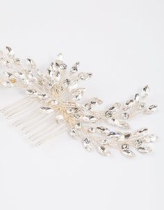 a close up of a hair comb on a white surface with lots of crystal beads