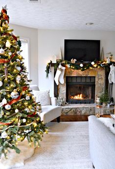 a living room with a christmas tree in the corner and stockings hanging on the fireplace