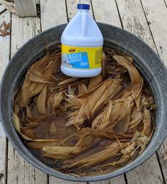 a bottle of deodorant sitting on top of a metal bowl filled with wood shavings