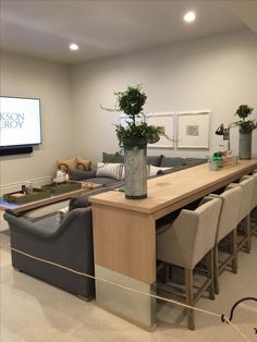 a living room filled with furniture and a flat screen tv mounted to the side of a wall