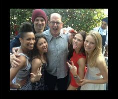 a group of people standing next to each other posing for the camera with their thumbs up