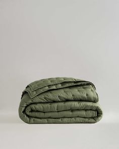 an olive green quilted blanket folded on top of each other