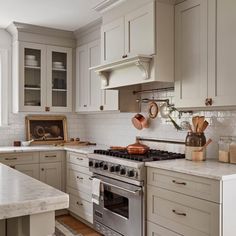 a kitchen with an oven, stove and counter tops in white painted wood paneling