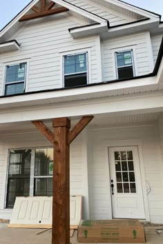 a white house with a large wooden cross on the front porch