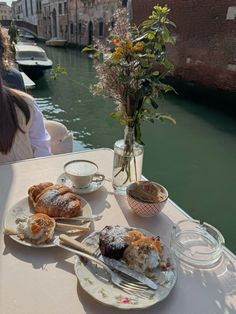 there is a plate of food on the table next to some cups and saucers