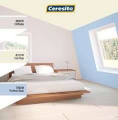 a bed sitting under a window in a bedroom next to a white floor and blue walls