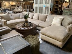 a living room filled with lots of couches and tables in front of a store