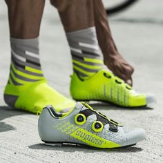 a close up of a person's shoes with yellow and grey socks on the ground