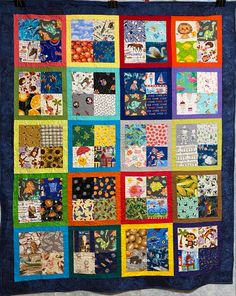 a colorful quilt hanging on the wall with many different designs and colors in it's center