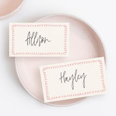 two place cards sitting on top of a plate next to each other with the word happily written on them