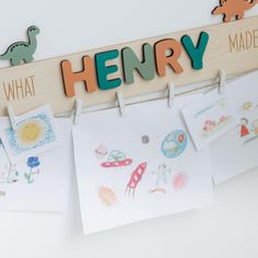 children's artwork hanging on clothes pegs with the word henry written above them