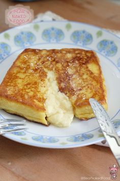 a piece of french toast on a blue and white plate with a fork next to it