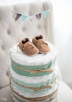 a stack of diapers with baby shoes on top