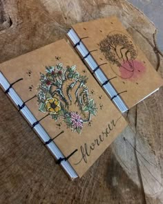 two notebooks sitting on top of a wooden table