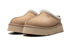 The Women’s UGG Tazz “Sand” is the women’s sizing of the slip-on moccasin with a platform style sole in a neutral colorway.  The Ugg Tazz Slipper is made for indoor or outwear wear, and features a warm inner lining constructed of plush sheepskin and upcycled wool.  The upper has a Sand-colored suede construction with an embroidered braid around the collar.  Uggs branding is seen on the lateral side.  The platform-style sole gives the wearer a significant boost in height, and is constructed in soft yet durable EVA foam for all-day comfort. Tazz Slipper, Brian Smith, Mid Jordan 1, Ugg Tazz, Ugg Ultra Mini, Nike X Travis Scott, All Jordans, Converse Run Star, Comfortable Slippers