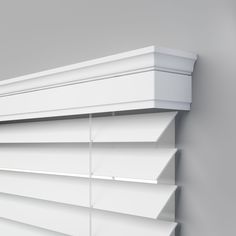 a white window blind hanging on the side of a wall