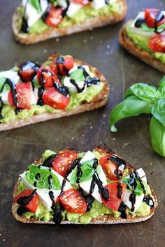 avocado, tomato and mozzarella on toasted bread with basil leaves