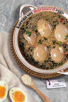 an egg and other food items are in a bowl on a table next to two spoons