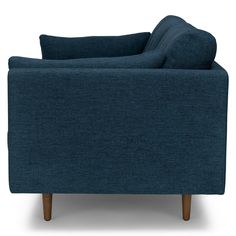 a blue couch sitting on top of a white floor next to a wooden leg chair