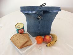 a lunch box with bread, fruit and yogurt in it sits on a table