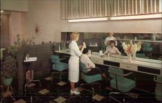 an old photo of a woman getting her hair done at a salon with two men in the background