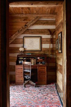 an old fashioned desk and chair in the corner of a room with wood paneling