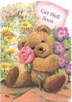 a brown teddy bear holding a pink rose in its paws and surrounded by flowers on the ground