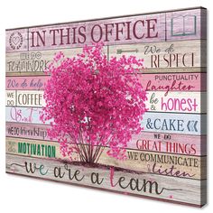 a wooden sign with pink flowers on it that says, in this office we are a team