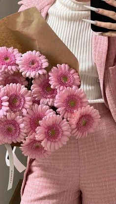 a woman holding a bouquet of pink flowers