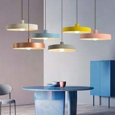 an assortment of lights hanging from the ceiling above a table