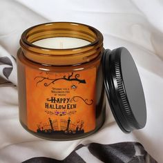 a jar of halloween candles sitting on top of a bed