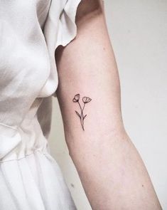 a small flower tattoo on the arm